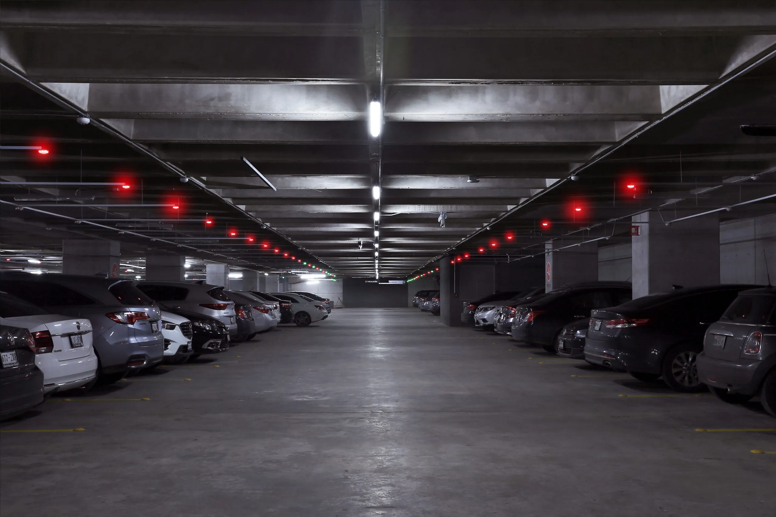 Nivel de estacionamiento con sensores rojos sobre cada cajón