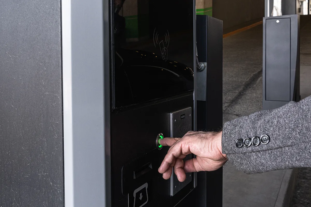 Usuario insertando un boleto en un cajero automático de estacionamiento